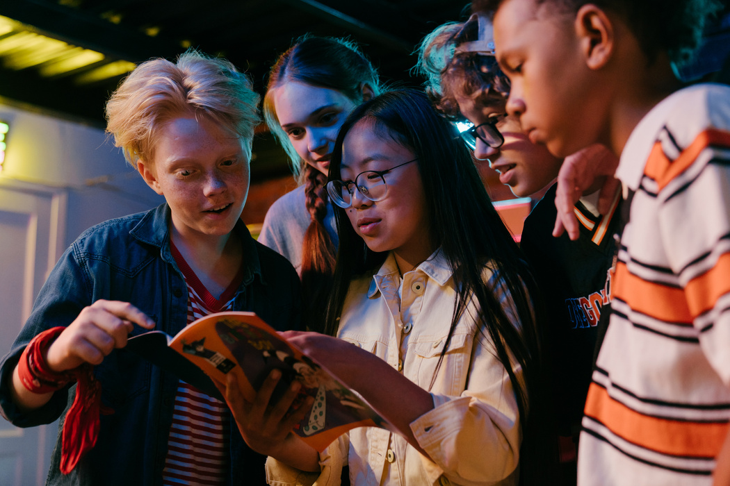 A Group of Teenagers Browsing Through a Magazine